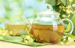 Липовый цвет, чайник и чашка с липовым чаем Липовый цвет, чайник и чашка с липовым чаем